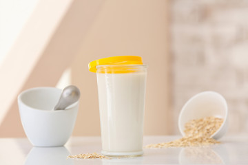 Obraz na płótnie Canvas Glass of tasty oat milk on table