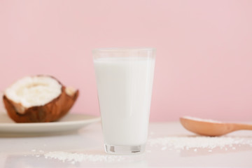 Glass of tasty coconut milk on table