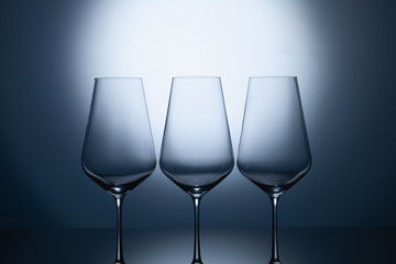 Empty wine glasses on a blue clean gradient background.