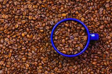 Blue tin mug full of coffee beans.