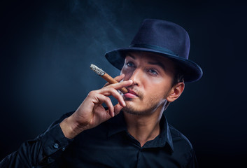 Gangster look. Handsome man with hat and cigar.