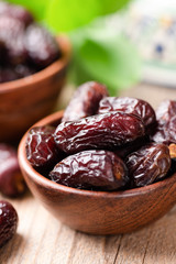 Dried medjool dates in bowl on wooden table background. Arabic Eastern Food
