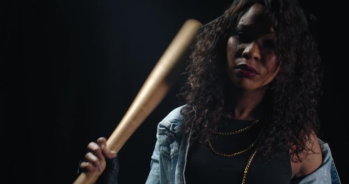Hot young woman in denim clothes is posing with a baseball bat, dangerous, 4k