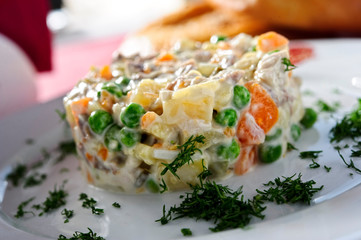 Russian traditional salad Olivier, isolated on table.