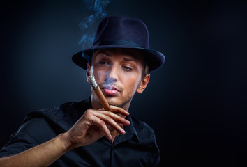 Gangster look. Handsome man with hat and cigar.