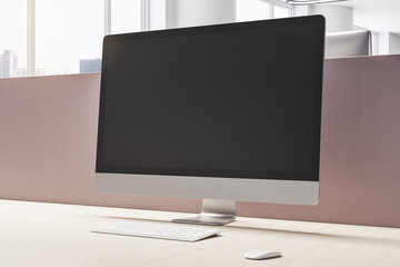 Designer desktop with empty black computer screen.