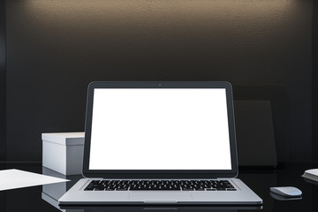 Laptop with empty white screen on office desktop.
