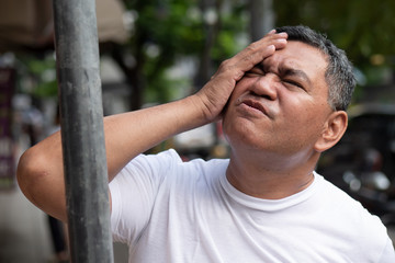 unlucky careless old senior man hitting his head with iron pole; concept of head injury, head...