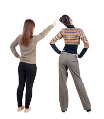 Back view of two young woman photographed on a mobile phone in sweater.