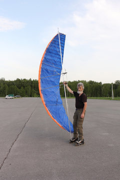 Man training in roller skating with kite