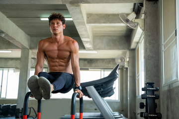 Sportsman exercising on parallel bars in the gym,Athlete builder muscles lifestyle.