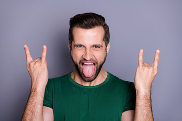 Portrait of childish playful positive cheerful guy show horned symbol enjoy rock concert have...