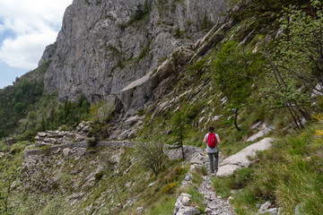 Female hiker on mountain pathway, Ligurian Alps, Italy