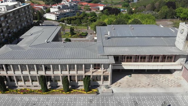 AERIAL DRONE FOOTAGE - Santo Tirso City Hall with the statue of Saint Rudesind (Sao Rosendo) in front, the 25th of April Square (Portuguese: Praca 25 de Abril) , Santo Tirso, Portugal.
