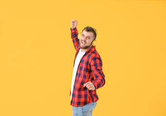 Handsome young man dancing against color background
