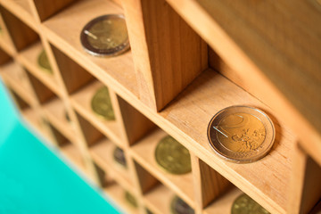 Monedas de euro en compartimentos de madera.
