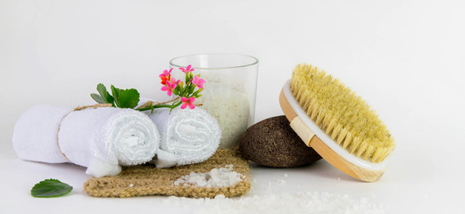 Eco set for spa treatments at home with towels, pumice, salt, candle on a white background.