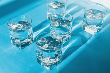 Transparent glasses of pure water on light blue surface. Health care
