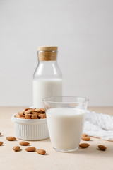 Almond milk in a glass and a glass bottle - alternative dairy.