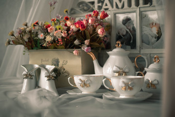 still life ceramic dishes with bow. flowes in a pot. Family photo frame.