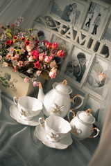 still life ceramic dishes with bow. flowes in a pot. Family photo frame.