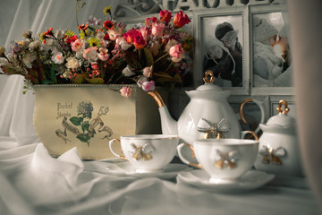 still life ceramic dishes with bow. flowes in a pot. Family photo frame.