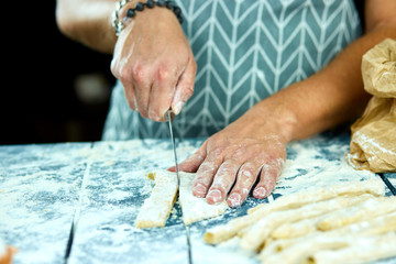 Closeup process making homemade pasta at home. Chef cook cutting with knife