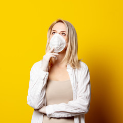 Blonde girl in face mask on yellow background.