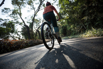 Naklejka premium Woman cycling on bike path at park on sunny day
