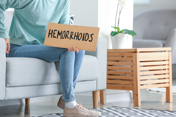 Young woman with hemorrhoids at home