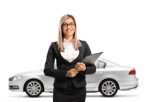 SSilver car behind a woman in formal clothes holding a clipboard with a document