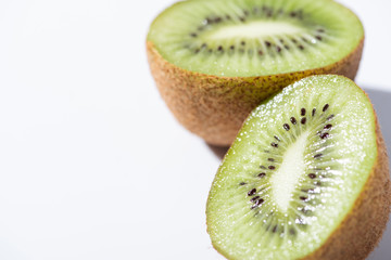 close up of kiwi fruit halves on white with copy space