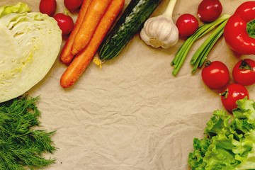 Fresh organic vegetables for a healthy diet on kraft paper background, top view. Background layout with free text space.