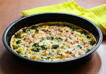 homemade pie with broccoli and cheese on the table close up