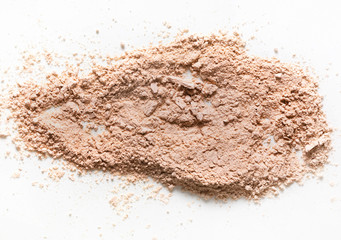 A loose peach nude beige powder pigmant for cosmetic or make-up on white background. Highlighter or...