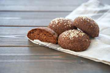 Keto bread. Tasty almond flour ketogenic buns, homemade with crust and sesame seeds on wooden board.