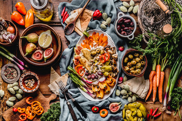 Tasty Mediterranean cuisine with healthy food with hummus plate. Ramadan iftar dinner. Various pickled and fresh  vegetables: olives, fids, green almond. Vegan party food Top view. Festive gathering