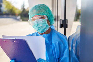 Mitarbeiter vor Klinik studiert Liste zur Kontaktverfolgung