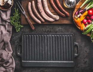 Grill or barbecue food background. Empty cast iron grill griddle and meat fork on rustic kitchen...