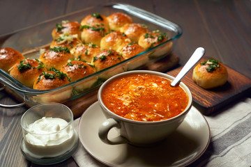 National ukrainian red borscht with sour-cream and buns pampushki.