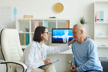 Side view portrait of caring female doctor comforting senior patient during consultation in clinic, copy space
