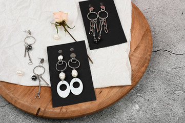 silver female earrings on a black background. laid out on a black sheet of paper