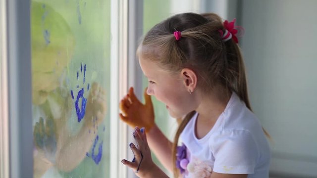 Children girl draw with palms on the window. Painted hands leave a mark on the glass. Quarantine. Stay home. Flash mob society community on self-isolation quarantine pandemic coronavirus.