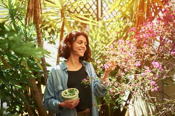 Woman on a terrace with a pot in her arms.