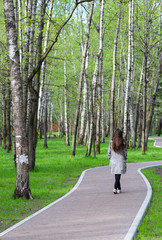 a girl walking through the Park on a winding path