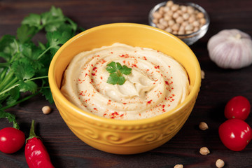 Plate of chickpea traditional hummus  on wooden background