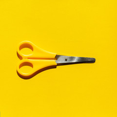Yellow trending scissors on background hard shadows.