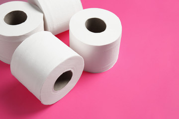 Rolls of toilet paper on color background