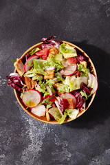 Traditional Middle Eastern Fattoush salad with pita bread,fresh vegetables and lemon sumac dressing on dark gray background top view.Healthy vegetarian food