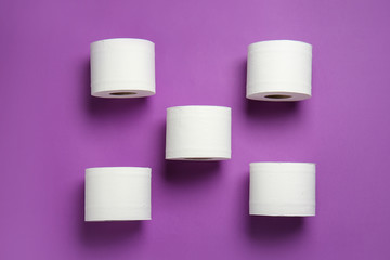Rolls of toilet paper on color background